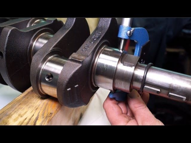 Micrometer measuring a crankshaft journal near a connecting rod